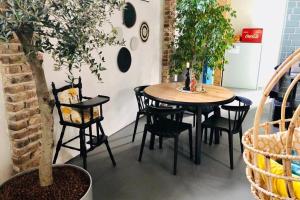 une table et des chaises dans une pièce avec un arbre dans l'établissement De slaaploods, à Kerkrade