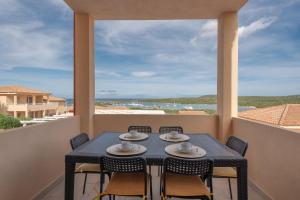 a table and chairs on a balcony with a view of the ocean at Baia de Bahas Residence in Golfo Aranci