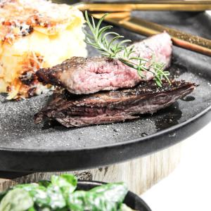 a plate of food with meat and a piece of cake at Lieblingsort - Cosy Black Forest Chalets in Neuenweg