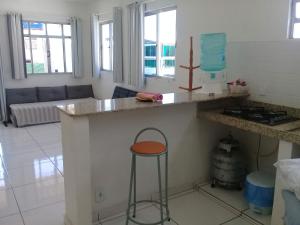 cocina con encimera y taburete en una habitación en Acomodações Araujo, en Arraial do Cabo