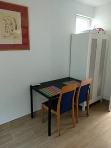 a black table with two chairs and a refrigerator at Magnificent studio - 2P - Next to Paris in Malakoff