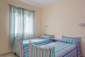 two twin beds in a room with a window at Baia de Bahas Residence in Golfo Aranci