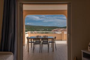 a dining room with a table and chairs on a balcony at Baia de Bahas Residence in Golfo Aranci