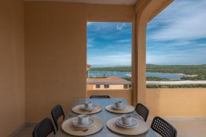 a table with hats and chairs on a balcony at Baia de Bahas Residence in Golfo Aranci