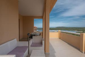 a balcony with a table and a view of the ocean at Baia de Bahas Residence in Golfo Aranci