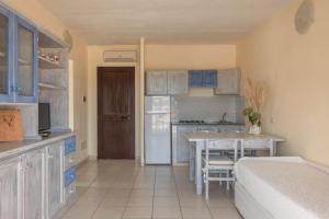 a kitchen with blue cabinets and a table in a room at Baia de Bahas Residence in Golfo Aranci
