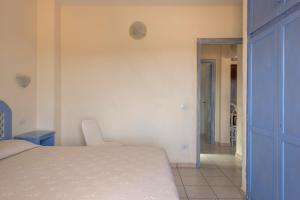 a bedroom with a bed and a blue door at Baia de Bahas Residence in Golfo Aranci