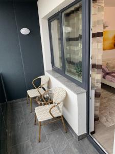 two chairs and a table next to a window at Top View Apartment in Suceava