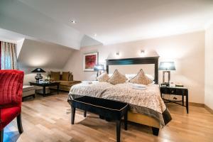 a large bedroom with a bed and a red chair at Deidesheimer Hof in Deidesheim +65 photos