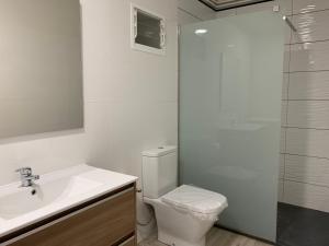 a bathroom with a toilet and a sink and a shower at Casa Madrileños in Outes