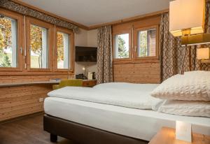 a bedroom with a large bed and windows at Hotel Landhaus in Münster