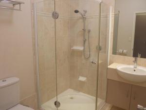 a bathroom with a shower with a toilet and a sink at Emerald Executive Apartments in Emerald