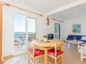 ein Wohnzimmer mit einem Tisch und Stühlen sowie einem Balkon in der Unterkunft Apartment Santa Lucia by Interhome in Montjoys