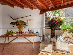 Holiday Home Los Jablitos by Interhome في Las Indias: طاولة وكراسي في فناء به زهور