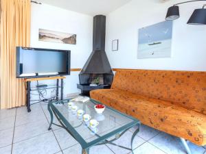 een woonkamer met een bank en een tv bij Holiday Home Don Quijote by Interhome in Llança