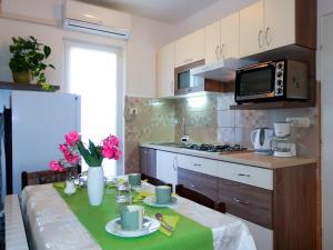 a kitchen with a table with a green table cloth at Apartment Sonja by Interhome in Rab