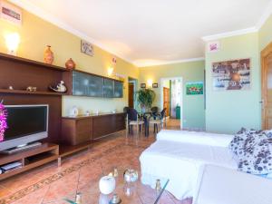 a living room with a white bed and a tv at Holiday Home Mila i Fontanals by Interhome in Roses
