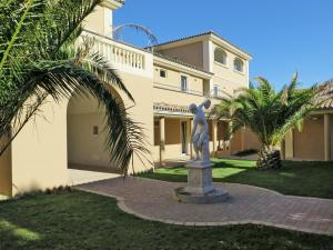una estatua frente a una casa con palmeras en Apartment Il Felciaione-8 by Interhome, en Riparbella
