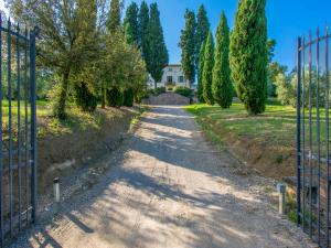 een poort naar een oprit met bomen en een huis bij Villa di Vinci by Interhome in Cerreto Guidi