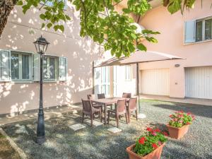 a table and chairs under an umbrella in a courtyard at Apartment Barbara-2 by Interhome in Santa Luce