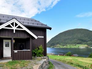 une grange avec une montagne en arrière-plan dans l'établissement Chalet Bøgeilen - FJM303 by Interhome, à Heggem