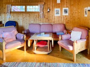 a living room with two chairs and a table at Chalet Holmestua - SOO398 by Interhome in Arendal