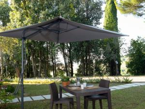 a table and chairs under an umbrella in a park at Apartment Barbara-4 by Interhome in Santa Luce