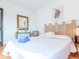 a bedroom with a white bed with blue towels on it at Holiday Home acacies by Interhome in Navata