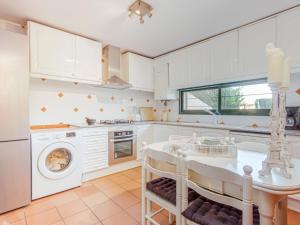 una cocina blanca con lavadora y secadora. en Holiday Home acacies by Interhome, en Navata