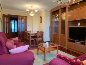uma sala de estar com um sofá roxo e uma mesa em Magnifico Piso Céntrico entre el mar y la montaña. em Colindres