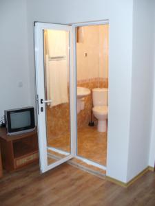a bathroom with a shower and a toilet and a television at Guest House Alfa Daniel in Balkanets +39 photos