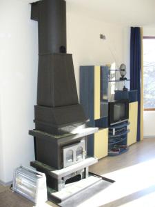 a fireplace in a living room with a tv at Guest House Alfa Daniel in Balkanets