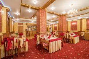 a restaurant with tables and chairs and a chandelier at Shery Holl in Rostov on Don