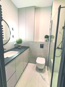 a bathroom with a toilet and a sink at Luxusowy Apartament Klimczaka in Warsaw