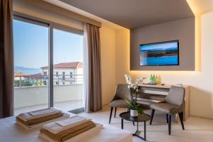 Palace Lido Hotel & Suites في مارينا دي سيسينا: غرفة مع طاولة وكراسي ونافذة كبيرة