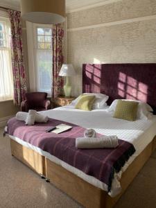 a bedroom with a large bed with towels on it at Inn in the Park in Bournemouth