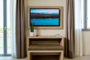 a flat screen tv sitting on a wall in a room at Palace Lido Hotel & Suites in Marina di Cecina