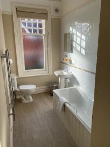 a bathroom with a tub and a toilet and a sink at Inn in the Park in Bournemouth