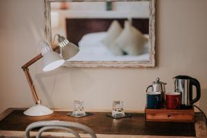 a desk with a lamp and a mirror on a wall at Inn in the Park in Bournemouth