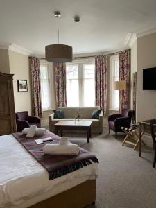 a bedroom with a bed and a living room at Inn in the Park in Bournemouth