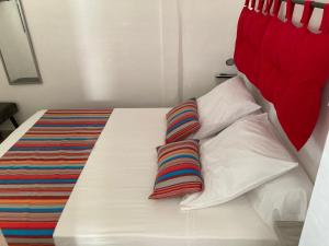 1 cama blanca con 2 almohadas y cabecero rojo en COROSSOL, en Trois-Rivières