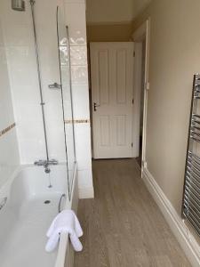 a bathroom with a tub and a shower with towels at Inn in the Park in Bournemouth +28 photos
