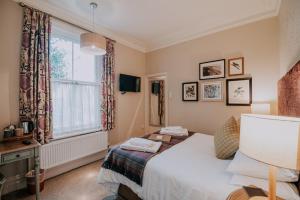 a bedroom with a bed and a window at Inn in the Park in Bournemouth