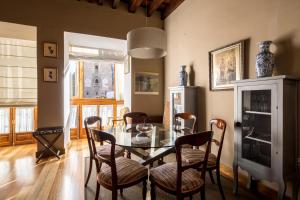 jadalnia ze szklanym stołem i krzesłami w obiekcie Veoapartment Casa Catedral w Sewilli