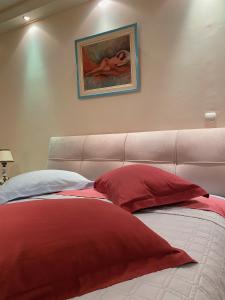 Cette chambre comprend un lit avec des oreillers rouges et blancs. dans l'établissement Pendeli's Luxury, à Athènes