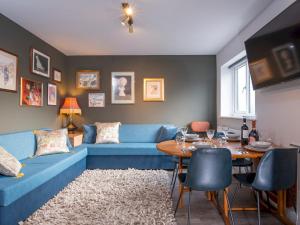 salon z niebieską kanapą i stołem w obiekcie Pass the Keys NEW Stylish & Elegant 2 Bed Apartment in the City! w Cardiff