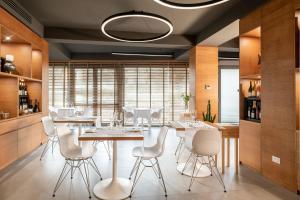 Palace Lido Hotel & Suites في مارينا دي سيسينا: غرفة طعام مع طاولة وكراسي بيضاء