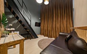 a living room with a couch and a staircase at Hotel Hue Loft in Incheon