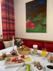 a table with a plate of meat and eggs and a candle at Hotel Wolfsjäger in Herbern