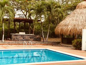 a swimming pool in a resort with a hut at finca Dan Pierre in Tocaima